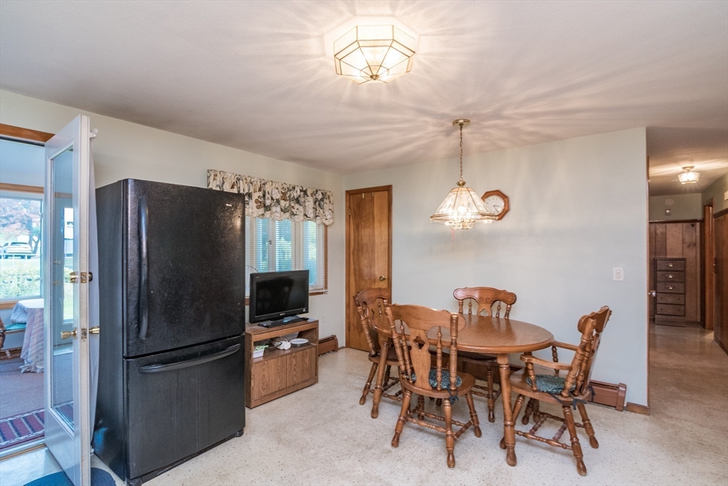 195 Mildred Avenue Springfield, MA 01104 - Photo 16 of 32 a kitchen with a refrigerator a dining table and chairs