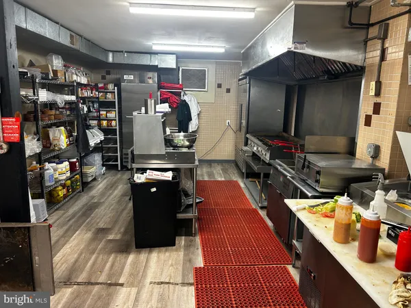 a kitchen with a stove and a wooden floor