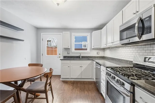 a kitchen with white cabinets and stainless steel appliances