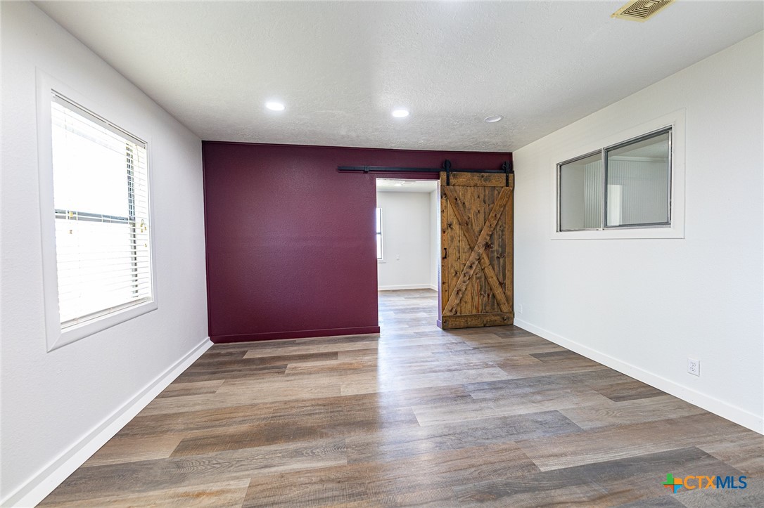 985 County Road 301 Shiner, TX 77984 - Photo 11 of 31 a view of an empty room with wooden floor and a window