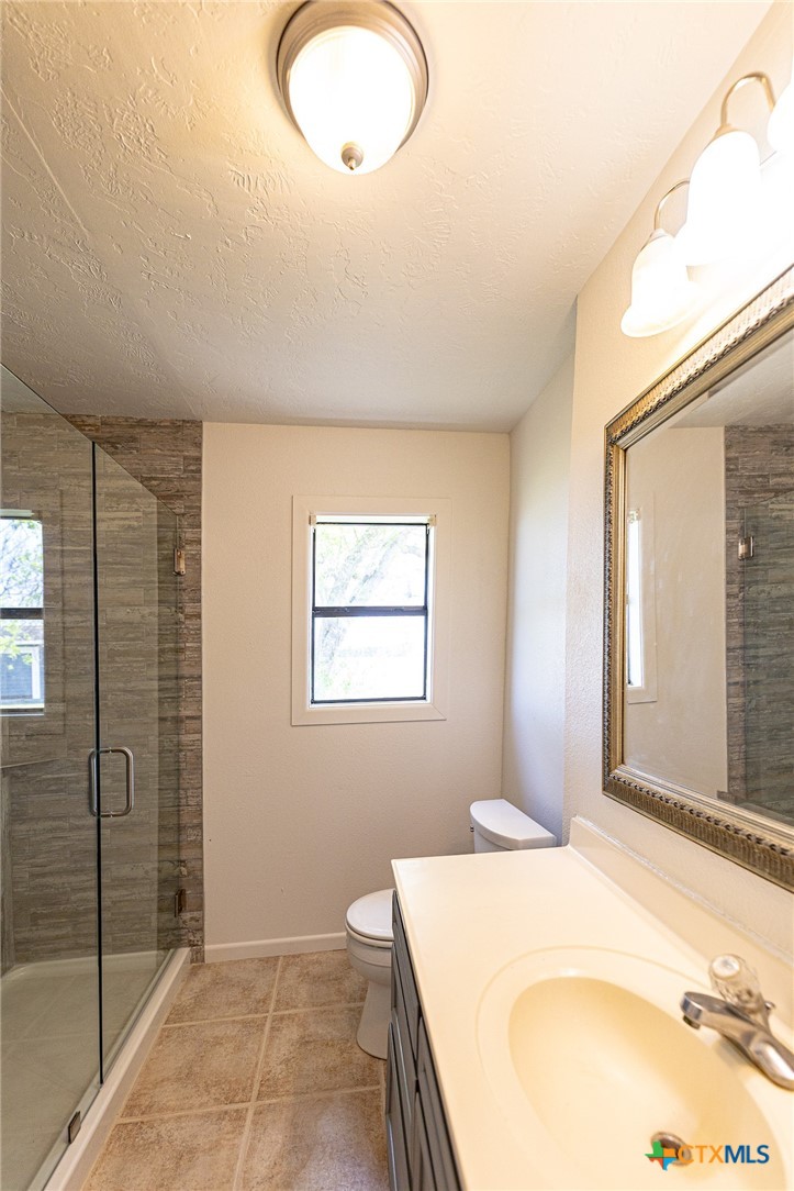 985 County Road 301 Shiner, TX 77984 - Photo 17 of 31 a bedroom with a bed and a chandelier