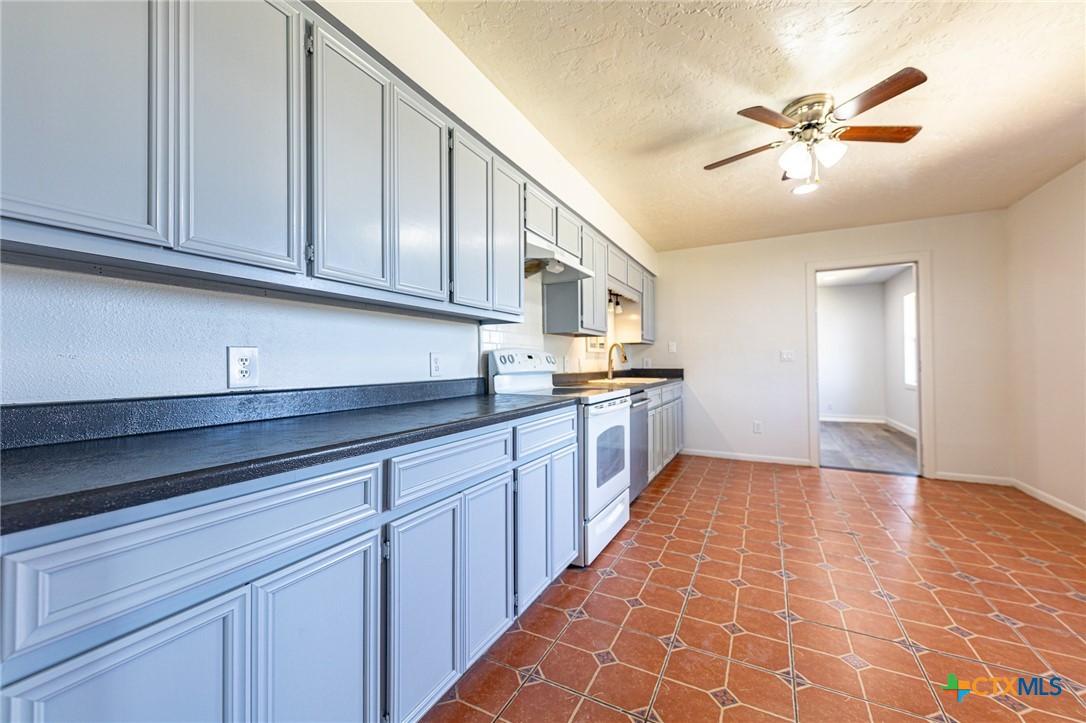 985 County Road 301 Shiner, TX 77984 - Photo 8 of 31 a large white kitchen with granite countertop a sink