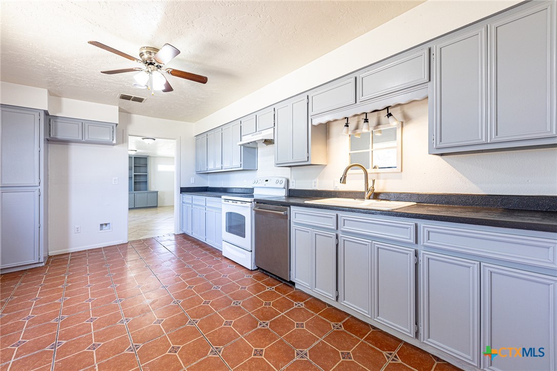 985 County Road 301 Shiner, TX 77984 - Photo 9 of 31 a kitchen with stainless steel appliances granite countertop a sink cabinets and window