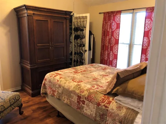 a bed sitting in a bedroom next to a cabinet