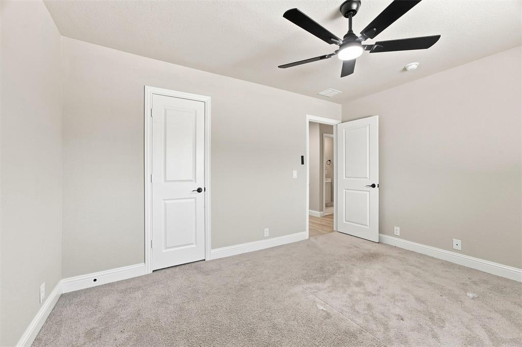 5225 Rowlan Row Midlothian, TX 76065 - Photo 24 of 33 Soft gray wall paint, light-colored carpeting, white trim, and a ceiling fan with integrated lighting