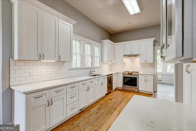 a kitchen with granite countertop white cabinets and white appliances