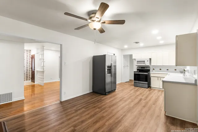 a kitchen with stainless steel appliances granite countertop a refrigerator and a stove top oven