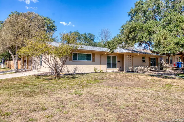 a backyard of a house with table and chairs