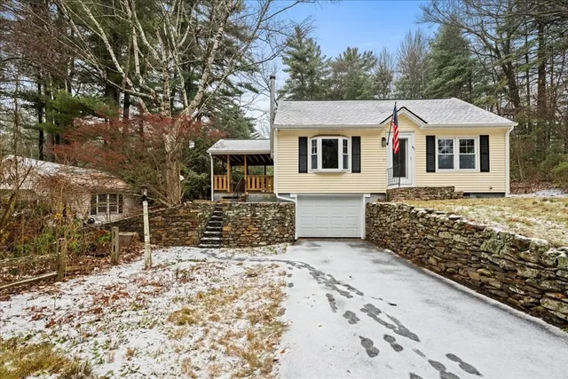 a front view of a house with a yard covered with snow in front of house