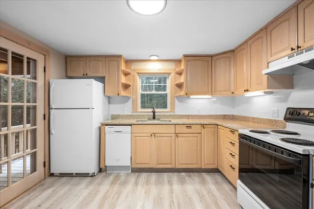 a kitchen with granite countertop white cabinets and white appliances