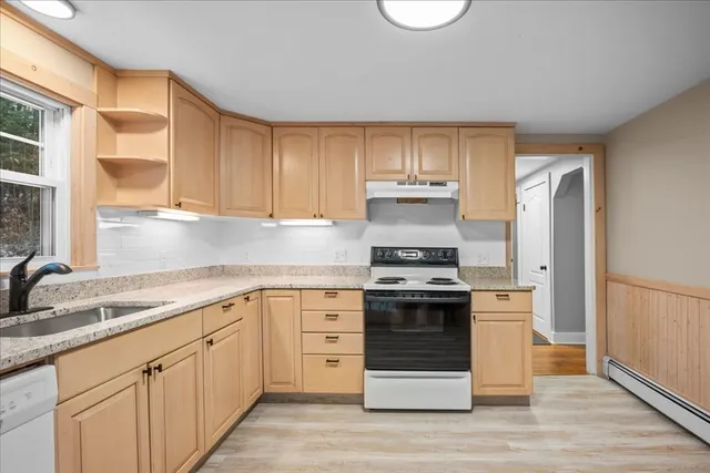 a kitchen with stainless steel appliances granite countertop a stove a sink and a refrigerator