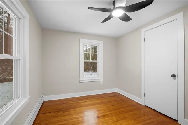 a view of an empty room with a window and a ceiling fan