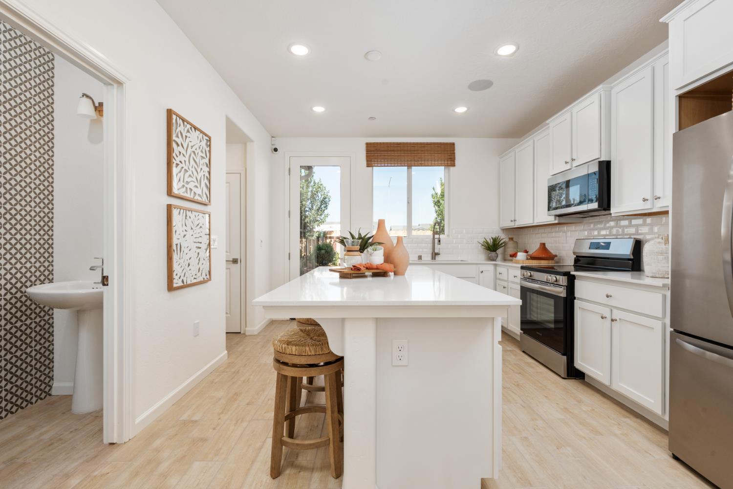 1477 Redbrick Lane Clovis, CA 93619 - Photo 8 of 33 a kitchen with stainless steel appliances granite countertop a refrigerator a stove top oven a sink dishwasher and white cabinets with wooden floor