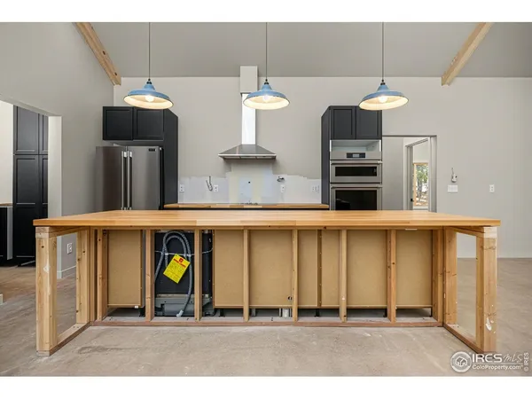 a kitchen with stainless steel appliances kitchen island a refrigerator sink and cabinets