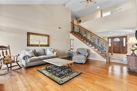 a kitchen with stainless steel appliances granite countertop a refrigerator a sink dishwasher a dining table and chairs with wooden floor