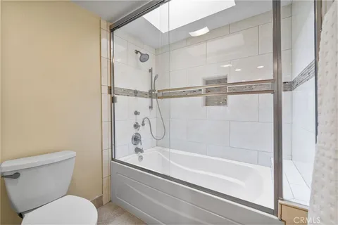 an aerial view of a city with lots of residential buildings and ocean view in back