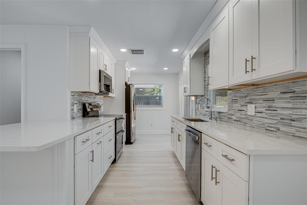 1806 Forest Drive Oldsmar, FL 34677 - Photo 5 of 23 a kitchen with granite countertop a sink and stainless steel appliances