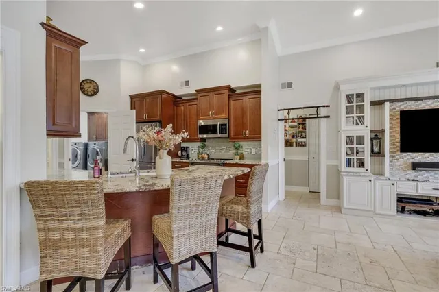 a kitchen with stainless steel appliances kitchen island granite countertop a sink and cabinets
