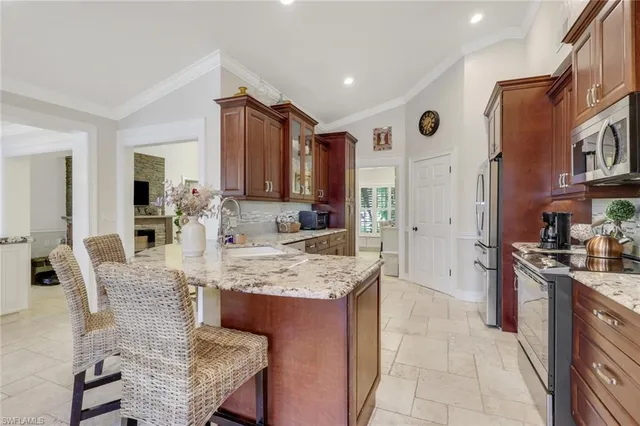 a large kitchen with stainless steel appliances granite countertop a stove top oven a sink a dining table and chairs