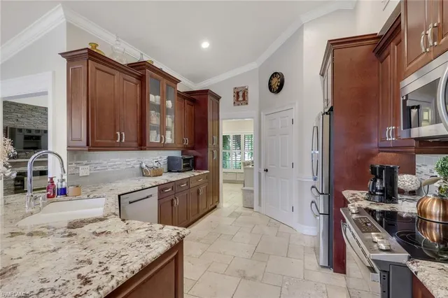 a kitchen with stainless steel appliances granite countertop a sink stove and refrigerator