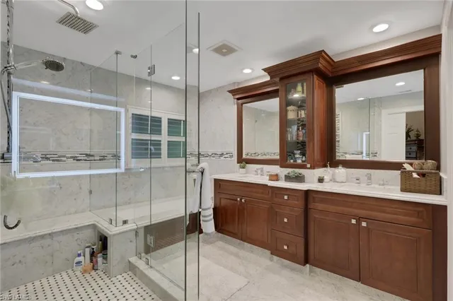 a bathroom with a double vanity sink a large mirror and shower