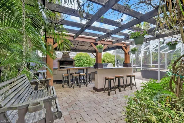 a view of a patio with table and chairs potted plants and large tree