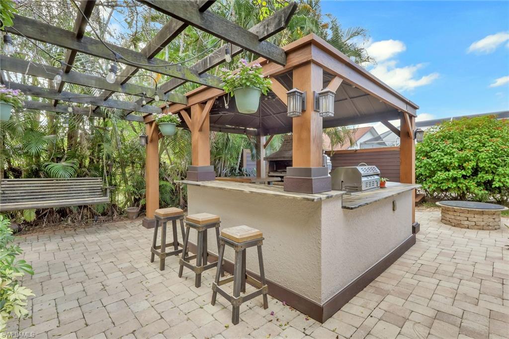 431 Ibis Way Naples, FL 34110 - Photo 34 of 37 a view of a patio with table and chairs and potted plants