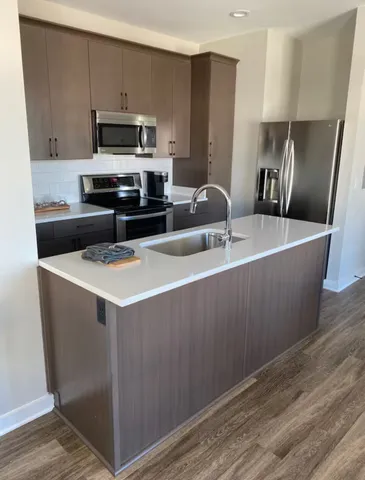 a kitchen with kitchen island a sink a stove and refrigerator