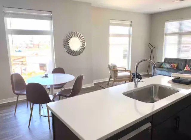 a kitchen with a table chairs and a large window