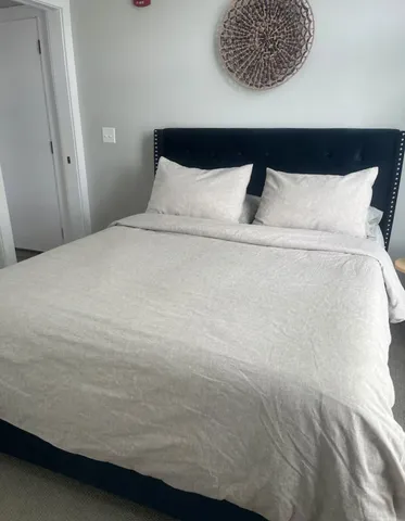 a bedroom with a bed and a painting on the wall