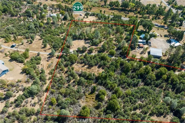 an aerial view of residential houses with outdoor space and trees