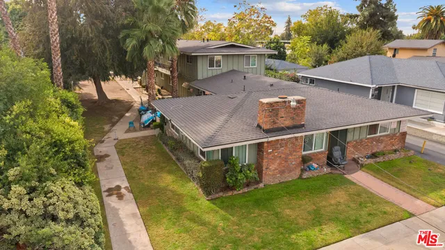 an aerial view of a house with swimming pool next to a yard