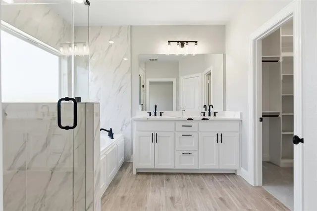 a spacious bathroom with a double vanity sink a mirror a shower and a bathtub