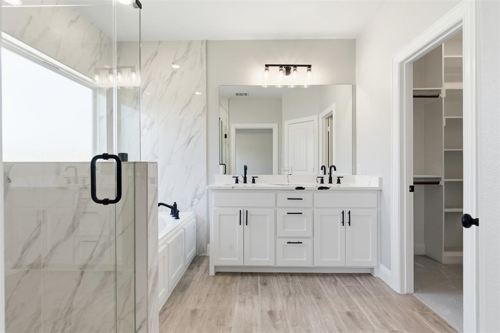 412 Ball Street Tom Bean, TX 75491 - Photo 15 of 28 a spacious bathroom with a double vanity sink a mirror a shower and a bathtub