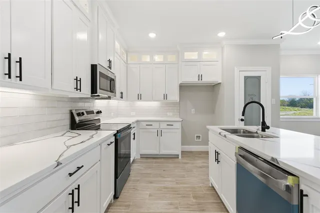 a kitchen with white cabinets stainless steel appliances and sink