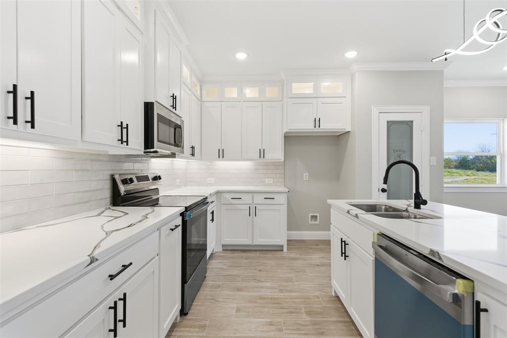 412 Ball Street Tom Bean, TX 75491 - Photo 5 of 28 a kitchen with white cabinets stainless steel appliances and sink