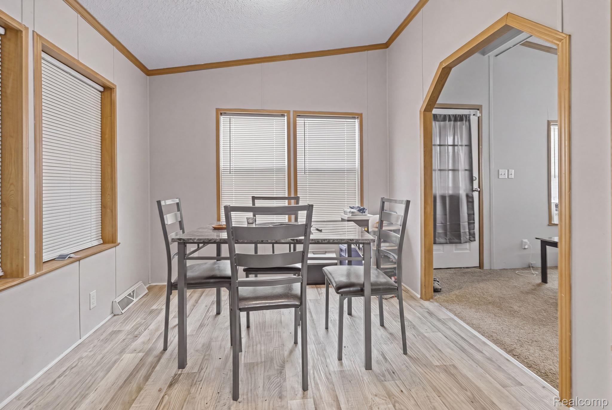 19921 Rhapsody Drive Clinton Township, MI 48036 - Photo 7 of 19 Wood-finish flooring, multiple windows with blinds, arched doorway, and light wall paneling