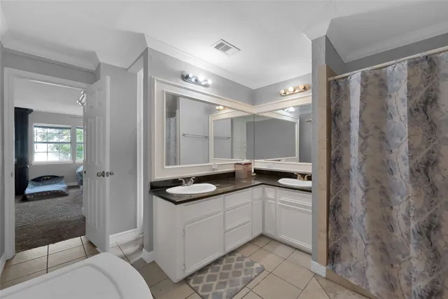 a en suite bathroom with a granite countertop sink a mirror and a shower