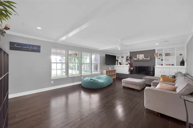 a living room with fireplace furniture and a large window