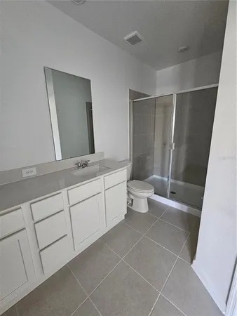 a bathroom with a double vanity sink toilet and mirror