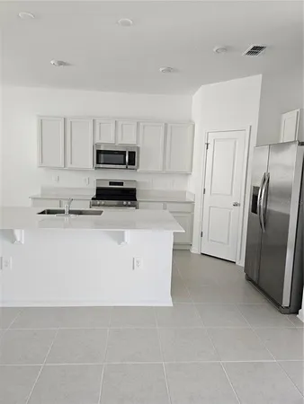 a kitchen with stainless steel appliances a refrigerator sink and cabinets
