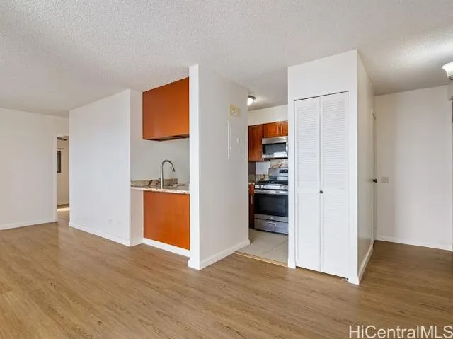 a view of a kitchen with wooden floor and a refrigerator