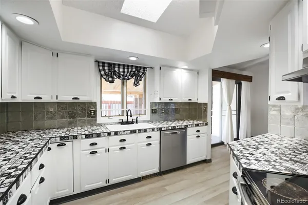 a kitchen with granite countertop a sink stove and cabinets