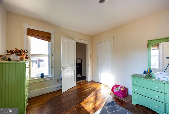a bedroom with a window and a dresser