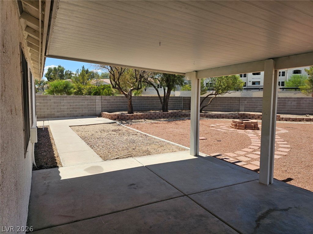 1418 Reebok Terrace Henderson, NV 89014 - Photo 29 of 38 A welcoming covered patio overlooks a low-maintenance yard featuring a decorative fire pit and paver pathway.