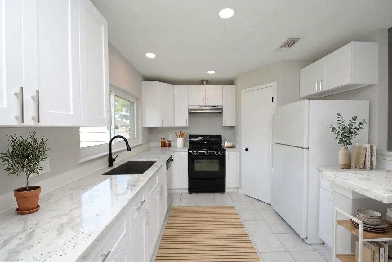22831 John Rolfe Lane Katy, TX 77449 - Photo 13 of 34 a kitchen with a refrigerator and a sink