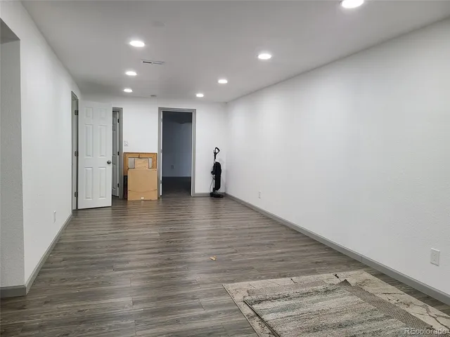 a view of empty room with wooden floor