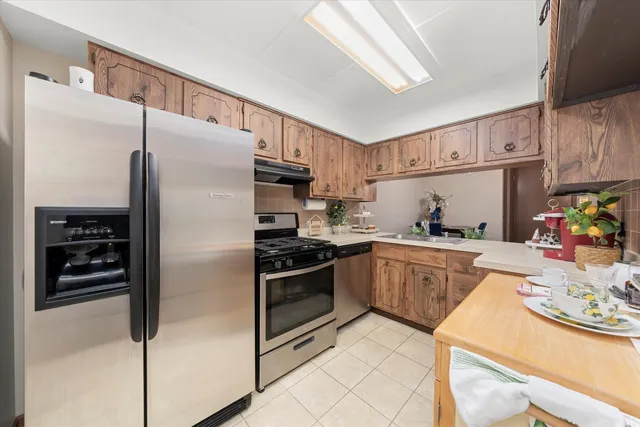 a kitchen with granite countertop a refrigerator stove and cabinets