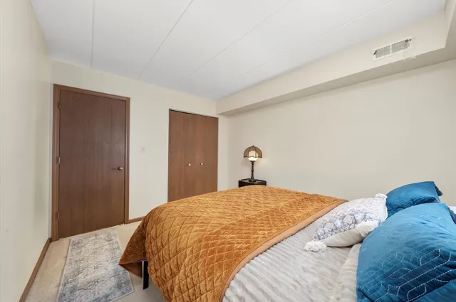 a bedroom with a bed and a lamp with the wooden floor