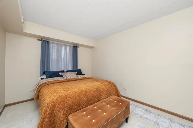 a bed sitting in a spacious bedroom next to a window